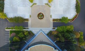 Aerial view of a commercial building with a parking lot and landscaped grounds, illustrating the property details documented in an ALTA title survey